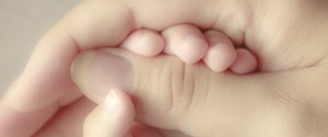baby holding his mothers finger, selective focus
